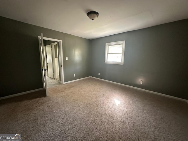 spare room with carpet flooring and baseboards