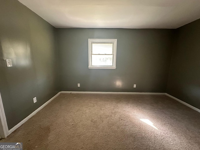 unfurnished room with carpet flooring and baseboards