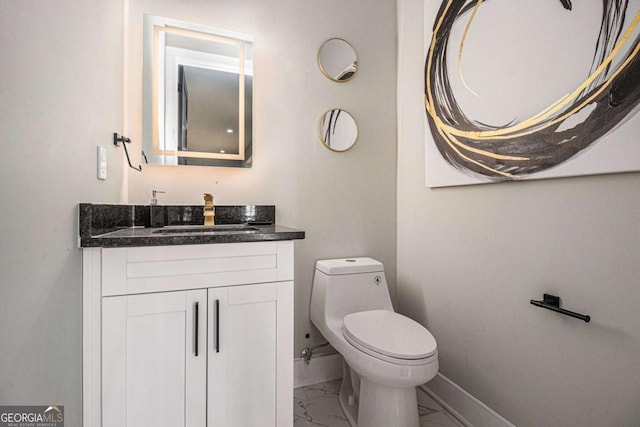 half bath featuring toilet, marble finish floor, baseboards, and vanity