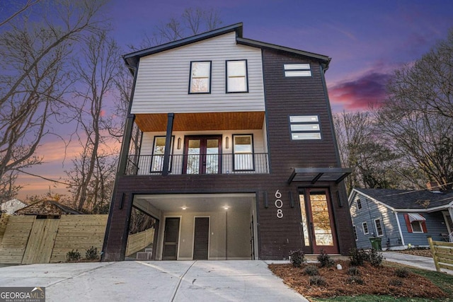 view of front of house with concrete driveway and a balcony