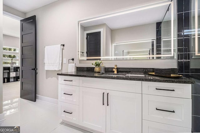 bathroom with vanity, baseboards, and tile patterned floors