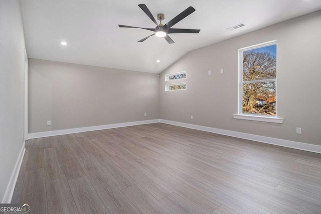 spare room featuring a ceiling fan, visible vents, baseboards, and wood finished floors