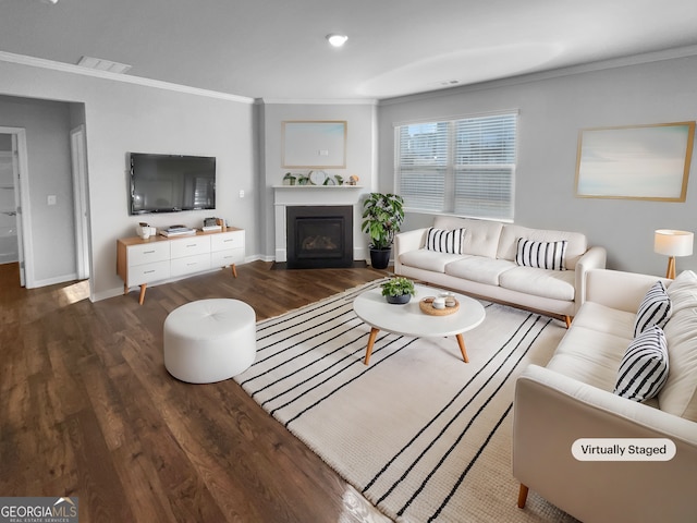 living room featuring crown molding, visible vents, a glass covered fireplace, wood finished floors, and baseboards