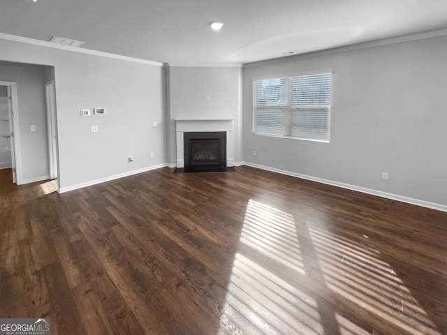 unfurnished living room with visible vents, baseboards, dark wood-style flooring, crown molding, and a fireplace