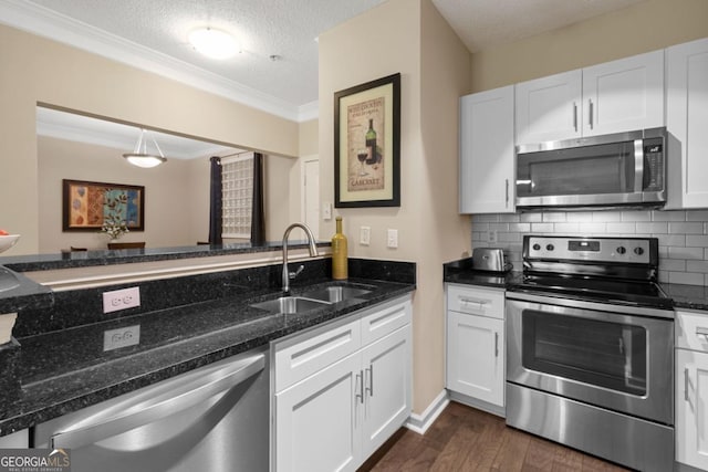 kitchen with stainless steel appliances, dark wood finished floors, a sink, and tasteful backsplash