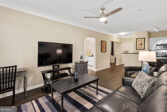 living area with dark wood-style floors, ornamental molding, baseboards, and a ceiling fan