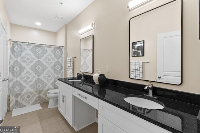 full bath featuring double vanity, tile patterned flooring, a sink, and toilet