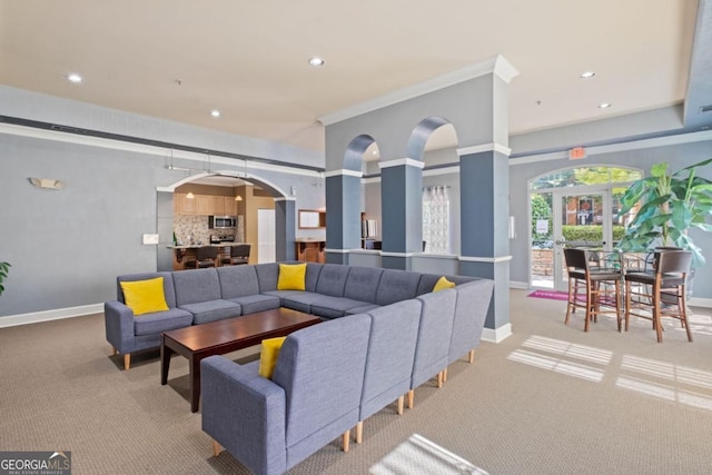 carpeted living area featuring arched walkways, recessed lighting, and baseboards