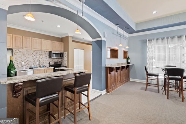 kitchen with arched walkways, ornamental molding, stainless steel appliances, light brown cabinetry, and backsplash