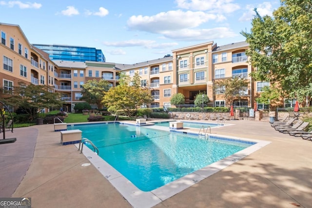 pool with a patio and fence