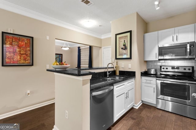 kitchen featuring stainless steel appliances, dark wood-style flooring, a sink, visible vents, and decorative backsplash