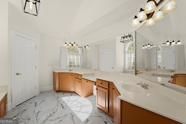 bathroom featuring marble finish floor, two vanities, a sink, and baseboards