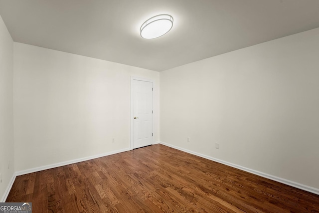 unfurnished room featuring dark wood finished floors and baseboards