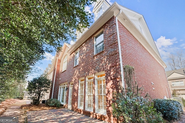 view of home's exterior with a patio and brick siding