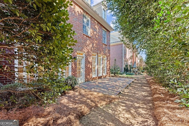 view of side of home with a patio area and brick siding