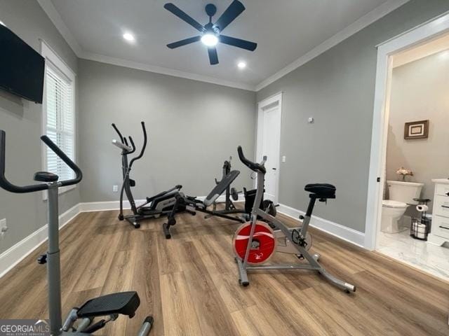 exercise area with ornamental molding, baseboards, and wood finished floors