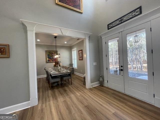 foyer with french doors, crown molding, baseboards, and wood finished floors