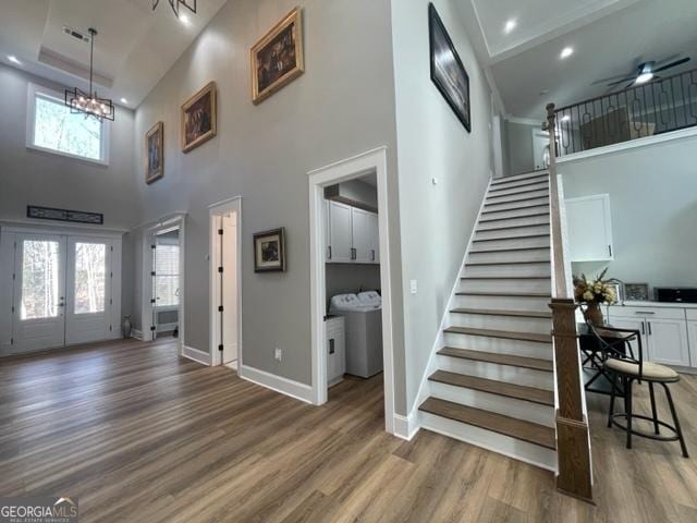 entryway featuring baseboards, stairway, wood finished floors, and a healthy amount of sunlight