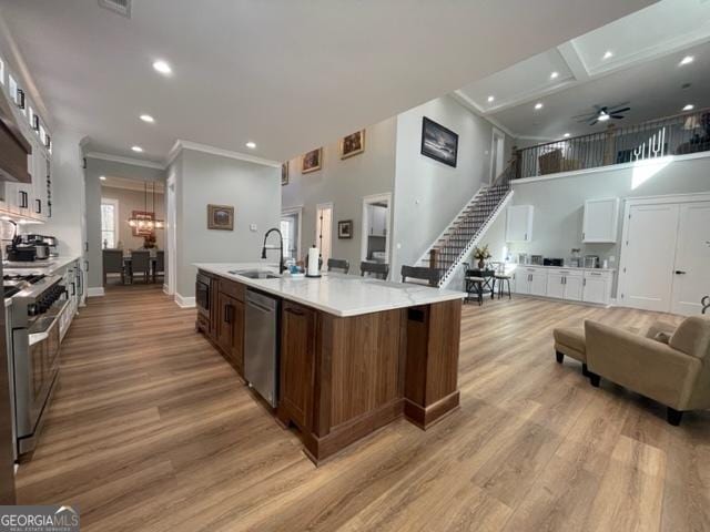 kitchen with open floor plan, light countertops, appliances with stainless steel finishes, a large island, and light wood finished floors