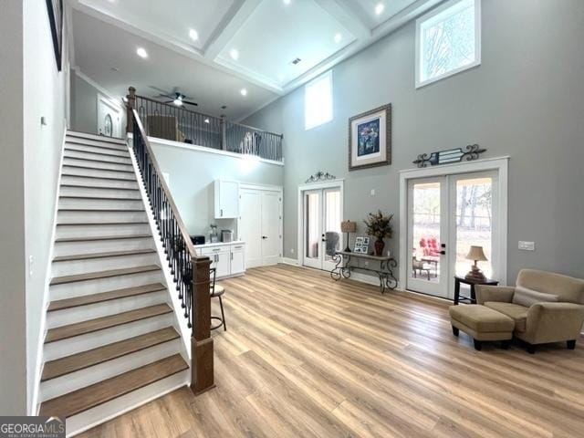 interior space with stairway, french doors, light wood-style floors, beam ceiling, and recessed lighting