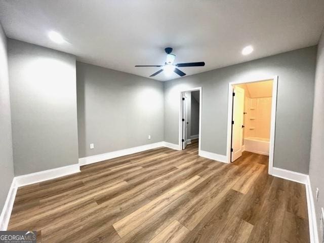 unfurnished bedroom featuring baseboards, ceiling fan, wood finished floors, a spacious closet, and recessed lighting