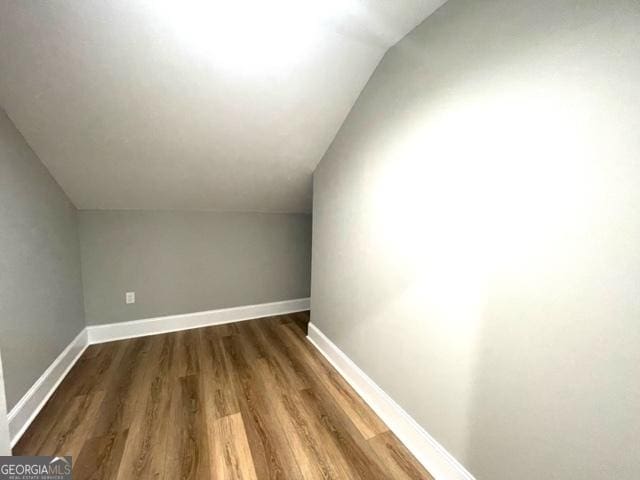 additional living space with lofted ceiling, wood finished floors, and baseboards