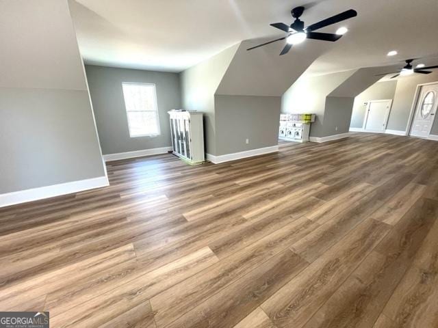 additional living space with a ceiling fan, baseboards, vaulted ceiling, and wood finished floors