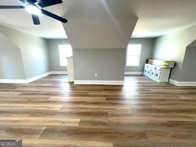 bonus room featuring wood finished floors, a ceiling fan, and baseboards