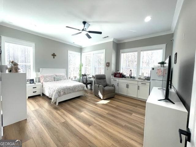 bedroom with a sink, a ceiling fan, visible vents, light wood-type flooring, and crown molding