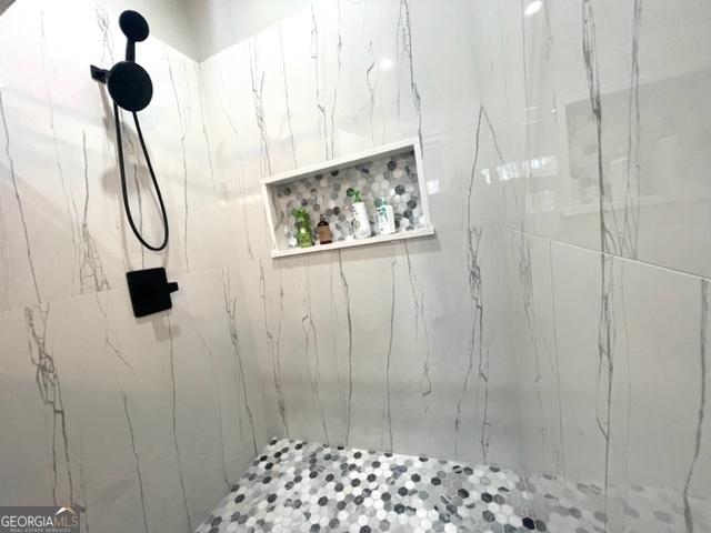 full bath featuring a marble finish shower