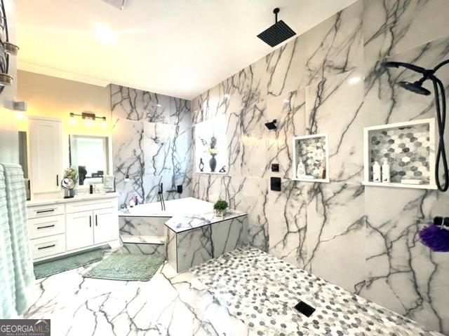 full bath featuring a marble finish shower, marble finish floor, vanity, stone wall, and a bath