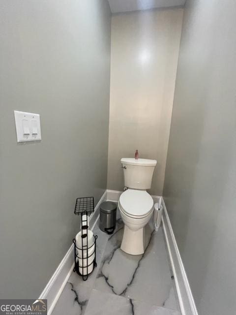 bathroom with toilet and baseboards