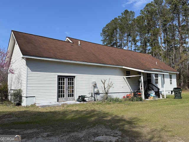 back of house with entry steps, roof with shingles, french doors, and a lawn