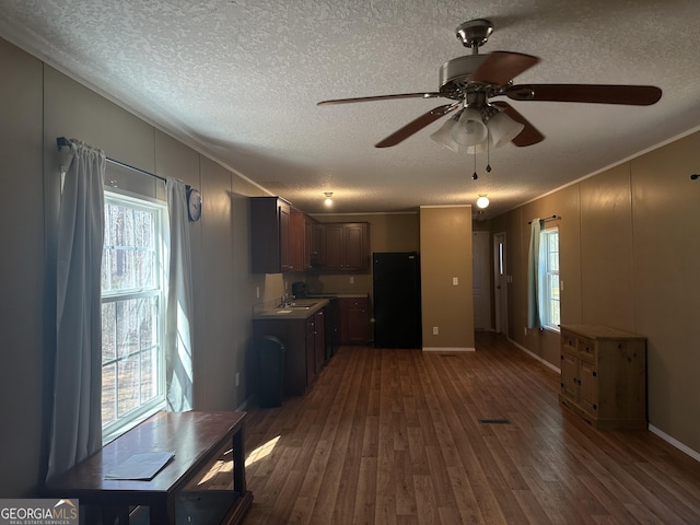 kitchen featuring ornamental molding, freestanding refrigerator, a textured ceiling, and wood finished floors