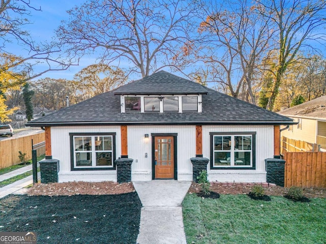 view of front of house featuring roof with shingles, fence, and central air condition unit