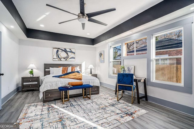 bedroom with multiple windows, baseboards, wood finished floors, and recessed lighting