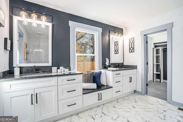 bathroom featuring marble finish floor, vanity, and baseboards