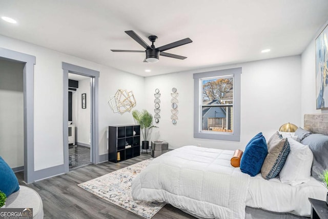 bedroom featuring recessed lighting, a ceiling fan, ensuite bath, wood finished floors, and baseboards