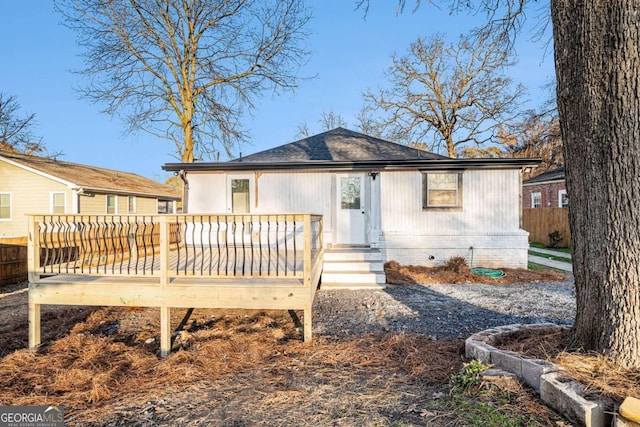 back of property with fence and a wooden deck