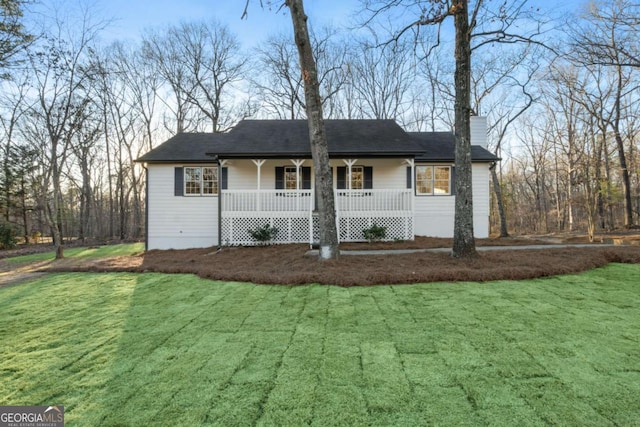 ranch-style house featuring a front yard, covered porch, and a chimney