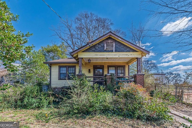 view of front facade featuring covered porch and fence