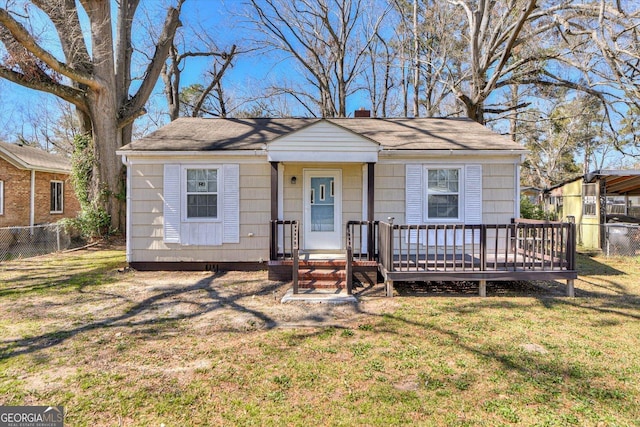 bungalow-style home featuring a chimney, fence, and a front lawn