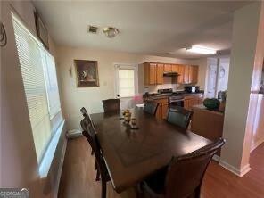 dining room with visible vents, baseboards, and wood finished floors