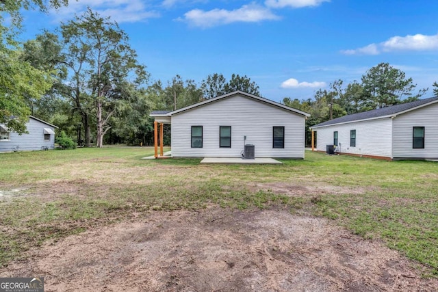 rear view of property with a patio area, central AC, and a yard