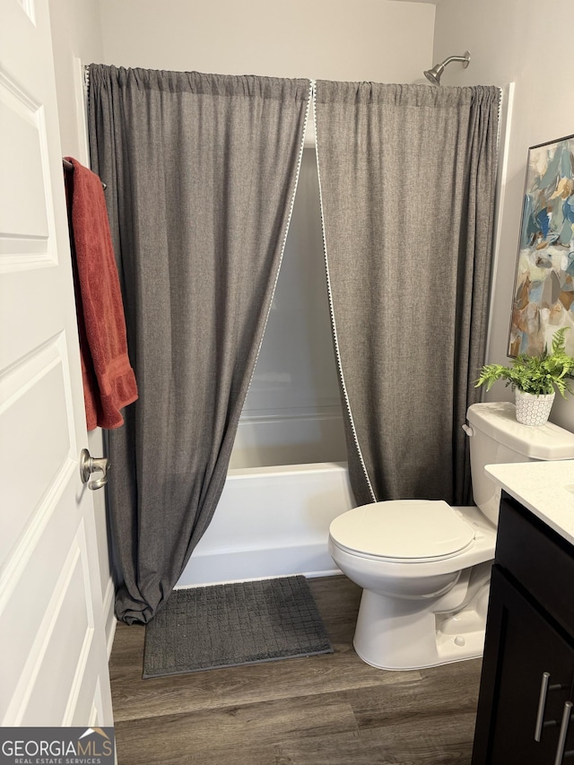 bathroom featuring shower / bath combo, vanity, toilet, and wood finished floors