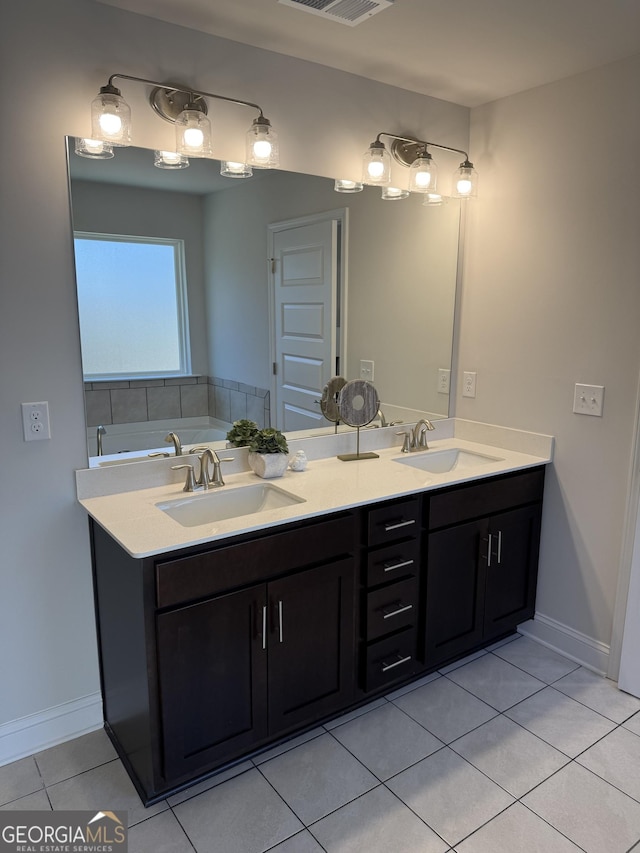 bathroom featuring tile patterned floors, a sink, baseboards, and double vanity