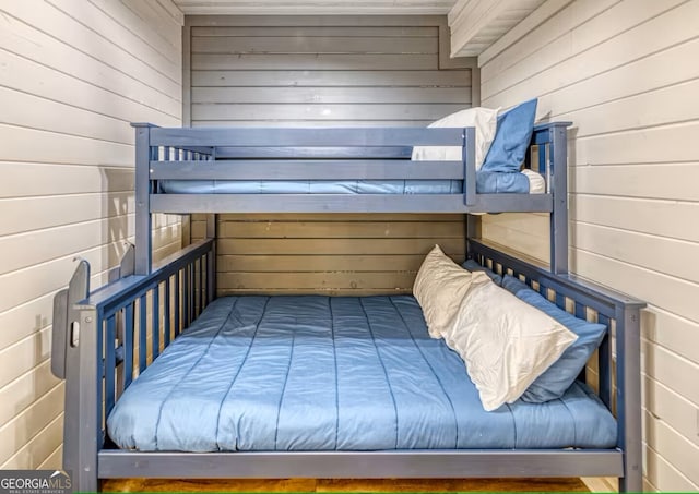 bedroom featuring wood walls