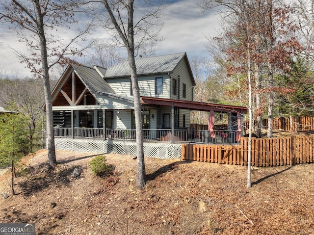 back of house with covered porch and metal roof