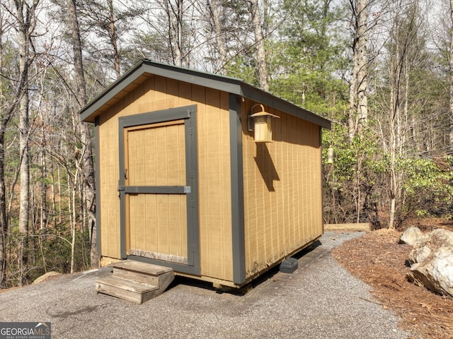 view of shed featuring a view of trees