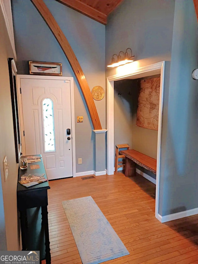 foyer with baseboards and hardwood / wood-style floors